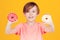 Kid enjoying sweets. Birthday party. Happy child having fun with donuts. Tasty food for kids. Colored donuts