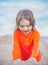 Kid enjoying time at the sand beach. Child making sandcastle on sea.