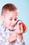 Kid examine apple with magnifying glass.