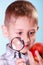 Kid examine apple with magnifying glass.