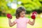 Kid exercising in park. Active boy, healthy lifestyle. Sport child with strong biceps muscles exercising dumbbell.