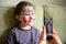 Kid with face painting of kitty, cute little girl with painted mask on face poses for photo