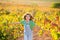 Kid farmer girl running in vineyard field in autumn