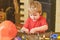 Kid fixing two metal details. Concentrated boy working with bolts. Preschooler helping in workshop