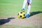 Kid football player standing and stepping on the ball