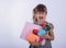 Kid gets ready for school. Schoolgirl holding many school supplies: pens, notebooks, scissors and apple. Back to school concept.