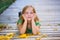 Kid girl in autumn wood deck with yellow leaves outdoor