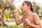 Kid Girl blowing soap bubbles in a park in summer