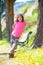 Kid girl with camouflage pants and cap in park bench outdoor