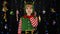 Kid girl in Christmas elf Santa Claus helper costume holding finger near lips for silence, hush sign