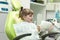 Kid girl in dentist`s chair looks in the mirror. Dental problem.