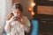 Kid girl drinking hot cocoa at home in winter weekend, sitting on cozy chair