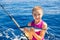 Kid girl fishing tuna bonito sarda fish happy with catch