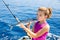 Kid girl fishing tuna bonito sarda kissing fish for release