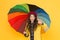 Kid girl happy hold colorful rainbow umbrella. Rainy weather with proper garments. Bright umbrella. Have fun. Positivity