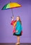 Kid girl happy hold colorful umbrella wear waterproof cloak. Enjoy rainy weather with proper garments. Waterproof