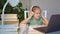 Kid girl in headphones listens to lesson, distance online learning home