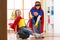 Kid girl and her mother weared Superhero costumes. Cute helper child and woman make cleaning room and have a fun.