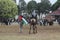 Kid, girl, horse, land, people. A muslim girl ride a horse and a little young man taking palestine& x27;s flag beside