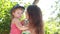 Kid girl kissing joying happy mother outdoors