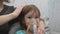 Kid girl makes inhalation with a nebulizer. sick child holding inhalator in hand and breathes through an inhaler at home