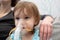 Kid girl makes inhalation with a nebulizer. sick child with mother holding inhalator in hand and breathes through an inhaler at