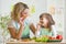 Kid girl and mother eating healthy food vegetables