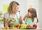 Kid girl and mother eating healthy food vegetables