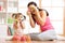 Kid girl and mother have a fun with puzzle toys. Young woman and child toddler sitting on floor and playing educational