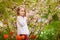 Kid girl near with almond bush and tulips