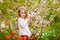 Kid girl near with almond bush and tulips