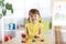 Kid girl playing with logical toy on desk in nursery room or kindergarten. Child arranging and sorting colors and sizes