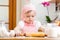 Kid girl preparing dough in the kitchen