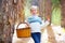 Kid girl searching chanterelles mushrooms with basket in autumn