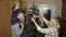 Kid girl with senior grandmother and grandfather decorating artificial Christmas tree with toys