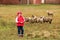 Kid girl shepherdess happy with flock of sheep