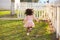 Kid girl toddler playing running in park rear view