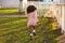 Kid girl toddler playing running in park rear view