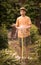 Kid hands hold hose with squirting water on the summer sunny green garden