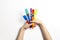 Kid hands holding colorful paintbrushes over white background