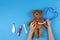 Kid hands play with toy stethoscope, teddy bear and toy medicine tools on light blue background. Top view