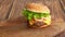 Kid hands take hamburger with a wooden board.