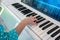 Kid hands on upright white piano with digital screen