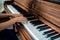 Kid hands on upright wooden piano.