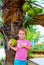 Kid harvests the young coconuts in tropical garden