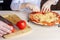 Kid help his dad to cookes homemade pizza. Family pastime during quarantine. Process of cooking pizza by child. Stay at home,