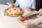 Kid help his dad to cookes homemade pizza. Family pastime during quarantine. Process of cooking pizza by child. Stay at home,