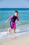 Kid in his diving suit leaving water at the beach