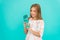 Kid hold bottle blue background. Child girl long hair has water bottle. Water balance concept. Healthy and hydrated