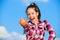 Kid hold ripe apple sunny day. Kid girl with long hair eat apple blue sky background. Healthy nutrition concept. Child